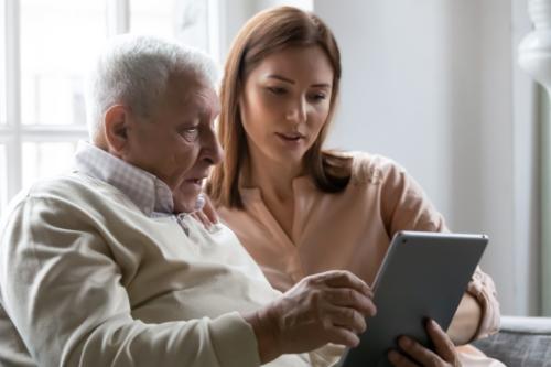 Caregiver help old man operate their ipad