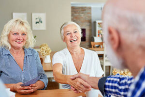 Old woman shaking hands with old man in senior living community