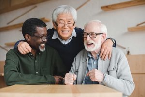 Happy old man joking with his friends