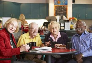 Senior citizens eating food prepared by chef on table