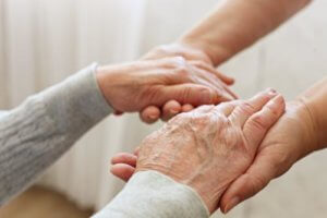 Caregiver hands grabs old woman hands