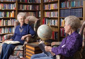 Senior citizens reading books together in the library