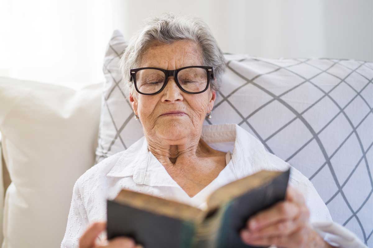 Old woman sit on the sofa and reading a book