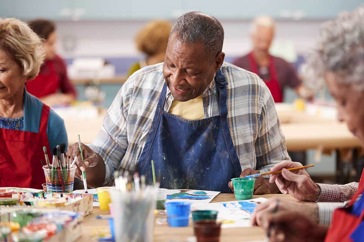 Senior citizens enjoy painting activities in the senior living community