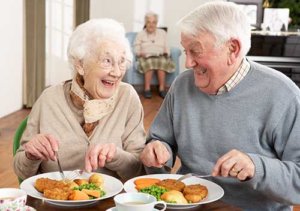 Senior couple eating food prepared by chef at lunch