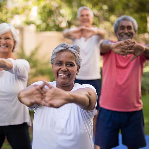 Happy senior citizens enjoying yoga exercises