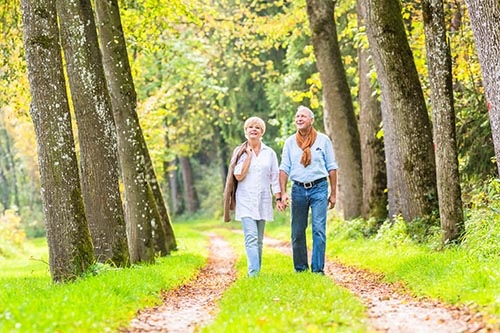 senior couple hands walking down path for suwanee georgia senior living activities